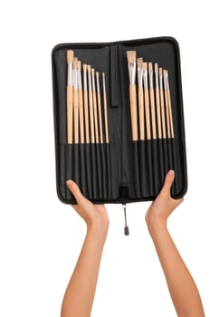 The woman chooses from a set of brushes one for drawing