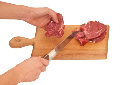 Slices of the meat on the board with knife on the kitchen