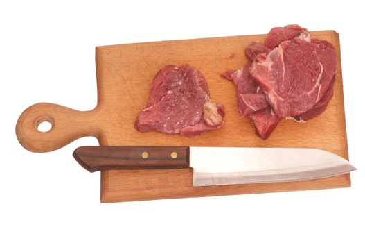 Slices of the meat on the board with knife on the kitchen