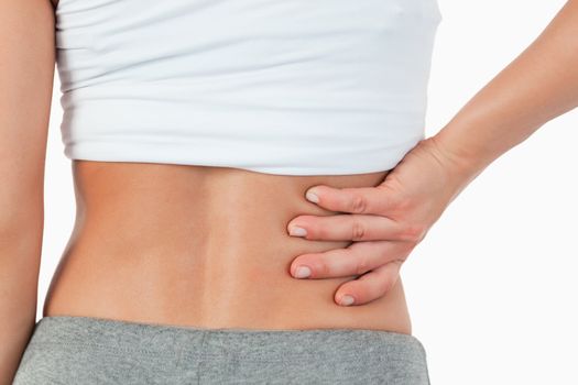 Close up of painful female back against a white background