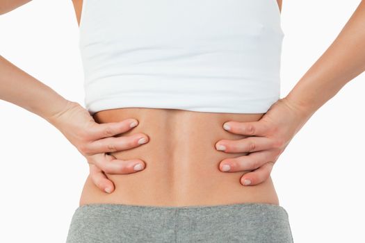 Close up of female hands on hip against a white background