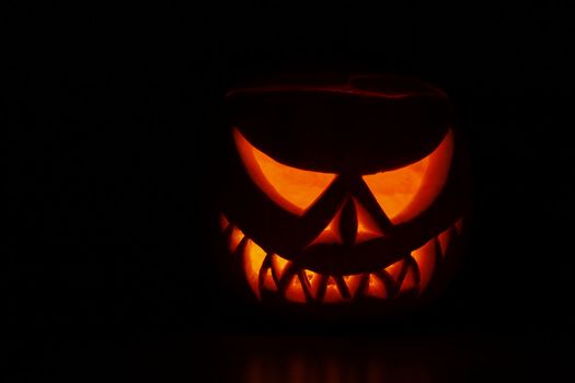 Pumpkin carved into spooky demon face for haloween