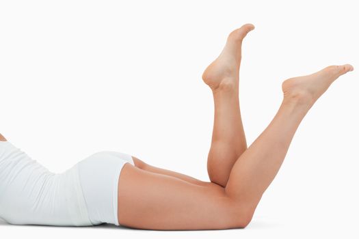 Feminine body lying on the floor against a white background