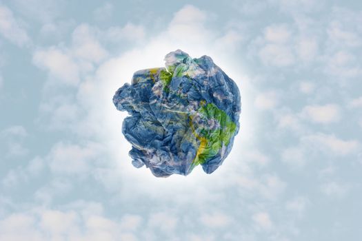 Planet paper trash over a cloudy sky background as a metaphor for environmental issues and concepts.