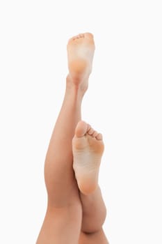 Portrait of fit feminine legs going up against a white background