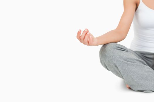 Fit woman in the Sukhasana position against a white background