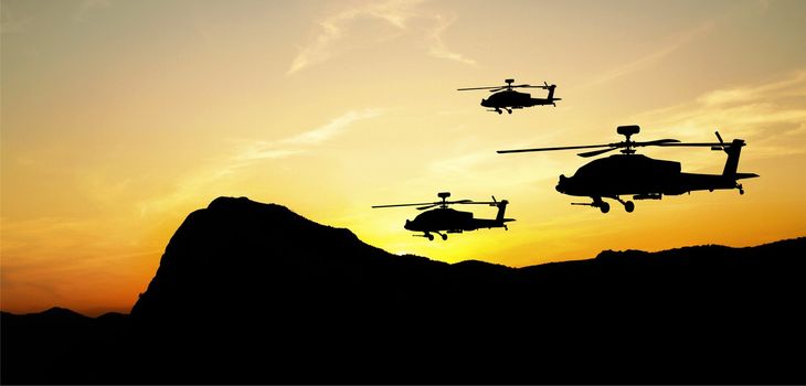 Flying helicopter silhouettes on sunset background
