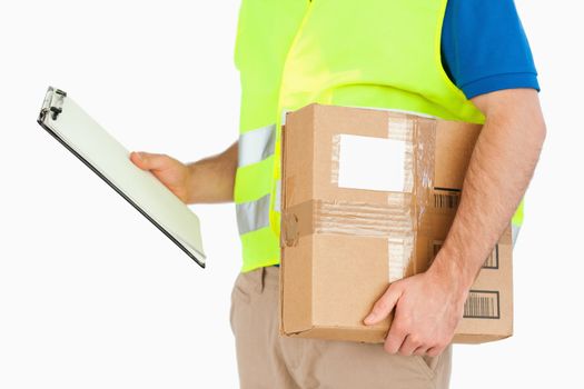 Side view of delivery man with delivery note and parcel against a white background