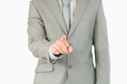 Businessman's finger activating futuristic touchscreen against a white background
