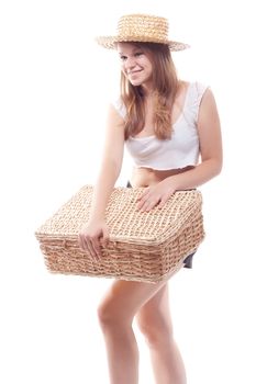A girl in a straw hat with a straw suitcase, studio photography