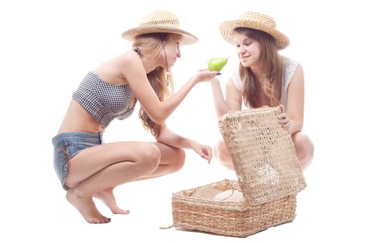 Two girls in straw hats with a straw suitcase, studio photography