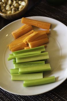 Sliced fresh celery and carrots on a plate served as crudties to dip in savoury dips and toppings
