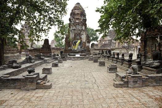 seated buddha statue and the ruins at wat mahathat, ancient city of ayutthaya, thailand