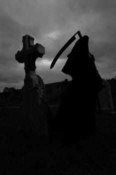 Silhoutte of the grim reaper in a graveyard