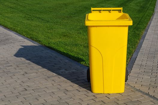 Big yellow recycling container in the park