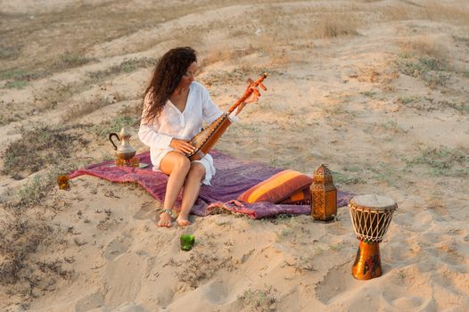 Woman with a sitar in a desert  setting