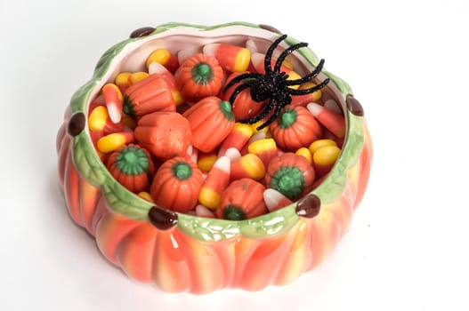 Candy corn in halloween dish with black toy spider