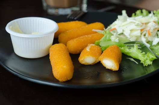 fried cheese with mustard served on dish in restaurant