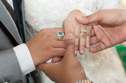 holding asian wedding lovers hands with diamond rings