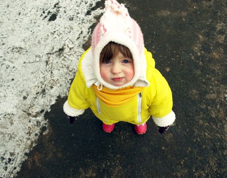 Funny little girl in warm clothes. Top view