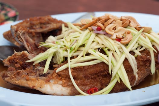 fried fish with papaya and cashew on top