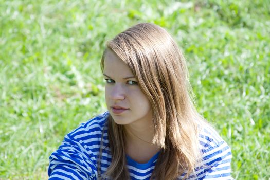 beautiful girl in the shirt on the grass outdoors shooting