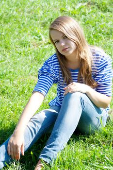 beautiful girl in the shirt on the grass outdoors shooting