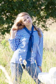 beautiful girl in the shirt on the grass outdoors shooting