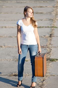beautiful girl with a suitcase outdoors shooting