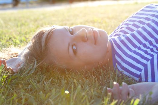 beautiful girl in the shirt on the grass outdoors shooting