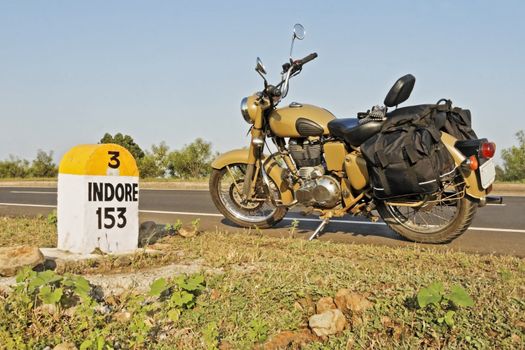 Indian motorcycle parked on NH3 Mumbai Agra Road at the 153kms milestone in the hinterlands of India