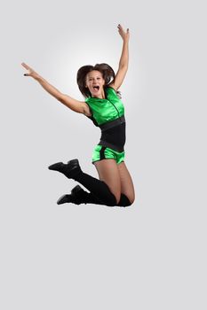 Young female dancer jumping against white background