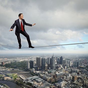 Business man balancing high over a cityscape