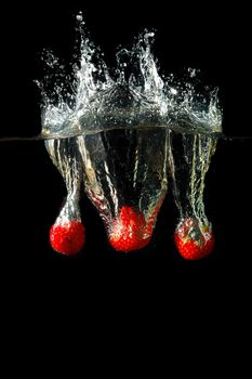 Colored red paprika in water splashes on black background