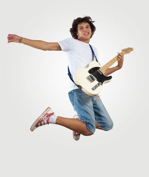 young man playing on electro guitar and jumping