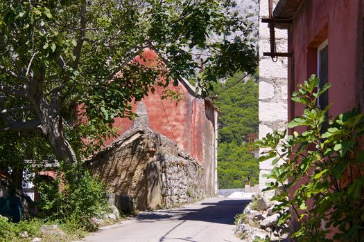 Street in old village of Tucepi with typical stone houses on Makarska Riviera in Dalmatia, Croatia