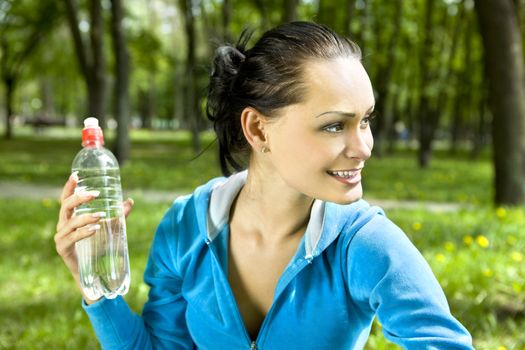 Pretty young girl runner in the forest with bottle of water