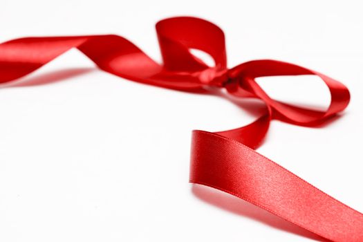 Shiny red satin ribbon on white background