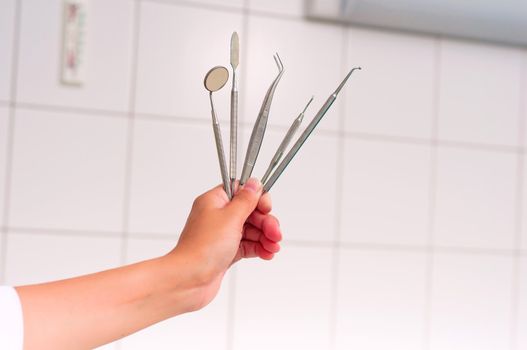 woman's hand holding a set of medical instruments