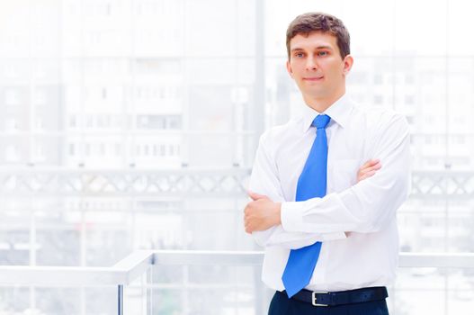 Smiling young business man crossed his arms