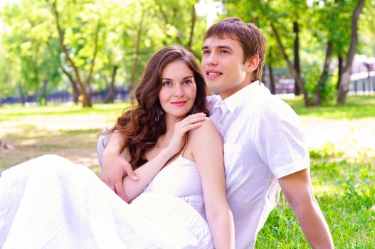 couple in the park sitting on the grass, have a good time together