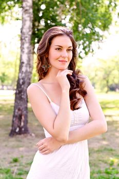 Portrait of an attractive woman in the park, crossed her arms