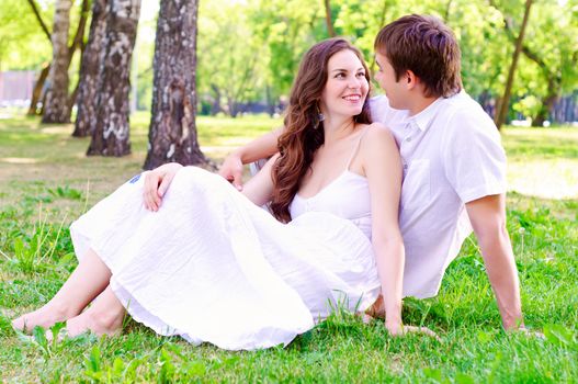 couple in the park sitting on the grass, have a good time together