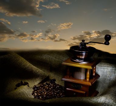 Coffee Mill with beans and burlap, with evening Sky