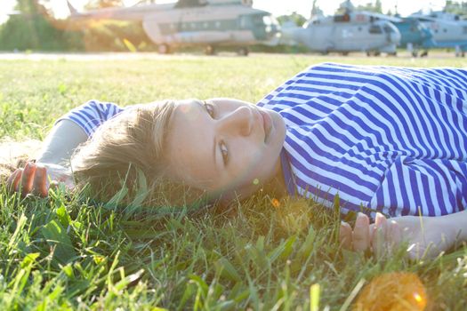 beautiful girl in the shirt on the grass outdoors shooting