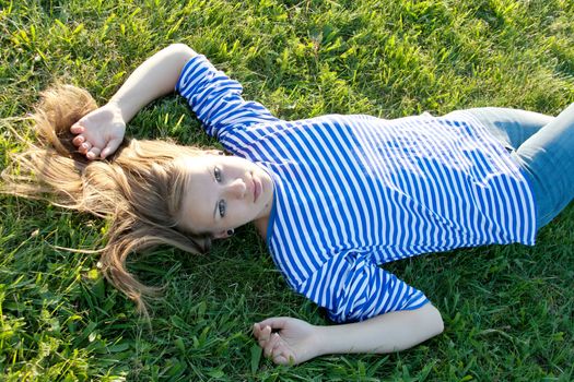 beautiful girl in the shirt on the grass outdoors shooting