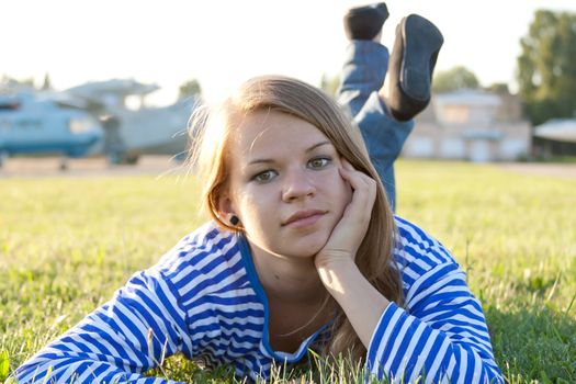 beautiful girl in the shirt on the grass outdoors shooting