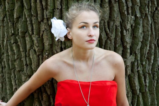 Pretty girl in red dress in the autumn in the woods shooting outdoors