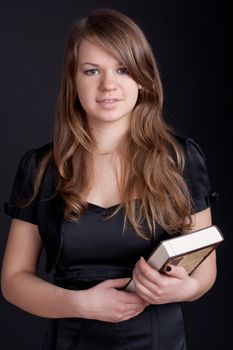 Girl with book in hand on a black background