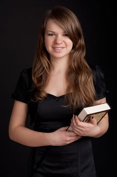 Girl with book in hand on a black background